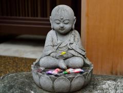 Cute Jizo sitting on a lotus